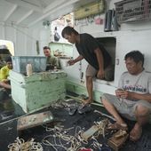 FILE - Foreign helpers do some maintenance work on their fishing tools while sitting on their boat docked at the Tomari fishery port in Naha in the main Okinawa island, southern Japan, on June 1, 2023. The Japanese government on Friday, Feb. 9, 2024, adopted plans to scrap its current foreign trainee program, criticized as a cover for importing cheap labor, and replace it with a new system that it says will actually teach skills and safeguard their rights as Japan desperately seeks to attract more foreign workers to supplement its aging and shrinking workforce. (AP Photo/Hiro Komae, File)