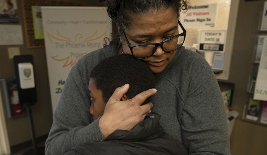 Tiffany McCarter, executive director of the African American Family and Cultural Center, hugs Josiah Banks before he leaves the center for the day in Oroville, Calif., Feb. 8, 2024. A measure aimed at transforming how California spends money on mental health will go before voters in March as the state continues to grapple an unabated homelessness crisis. McCarter fears the 14-year-old facility with a mission of breaking the cycle of trauma in the Black community, might have to close if it loses mental health funding from the Butte County.(AP Photo/Rich Pedroncelli)