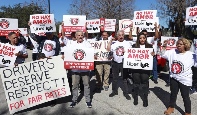 Ride-share drivers protest near Orlando International Airport at Airport Lakes Park, Wednesday, Feb. 14, 2024, in Orlando, Fla. Thousands of ride-hailing and delivery workers in the U.S. and the U.K. went on strike on Valentine&#x27;s Day, calling for higher pay and other changes to their working conditions. (Joe Burbank/Orlando Sentinel via AP)