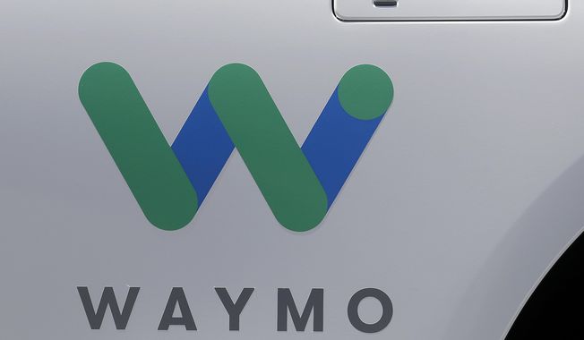 In this May 8, 2018, photo, a Waymo logo is displayed on the door of a car at the Google I/O conference in Mountain View, Calif. On Wednesday, some Uber Eats customers likely had their food delivered by a robot as part of Waymo’s partnership with Uber. (AP Photo/Jeff Chiu) **FILE**
