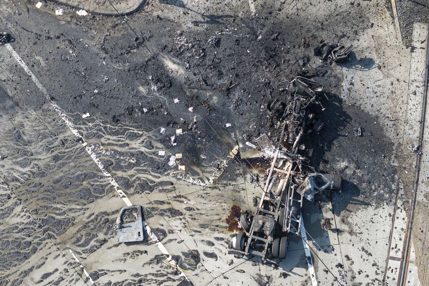 The tractor portion of a big rig is shown in an aerial view on Thursday, Feb. 15, 2024, in the Wilmington section of Los Angeles. Several Los Angeles firefighters were injured, two critically, when an explosion occurred as they responded to a truck with pressurized cylinders that were on fire early Thursday, authorities said. (AP Photo/William Liang)