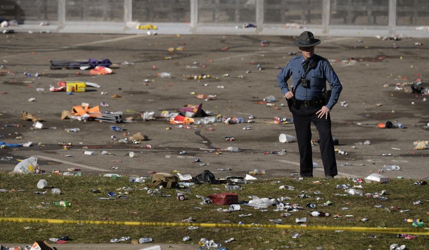 A law enforcement officer stands amid debris as he looks around the scene following a shooting at the Kansas City Chiefs NFL football Super Bowl celebration in Kansas City, Mo., Wednesday, Feb. 14, 2024. (AP Photo/Charlie Riedel, File)