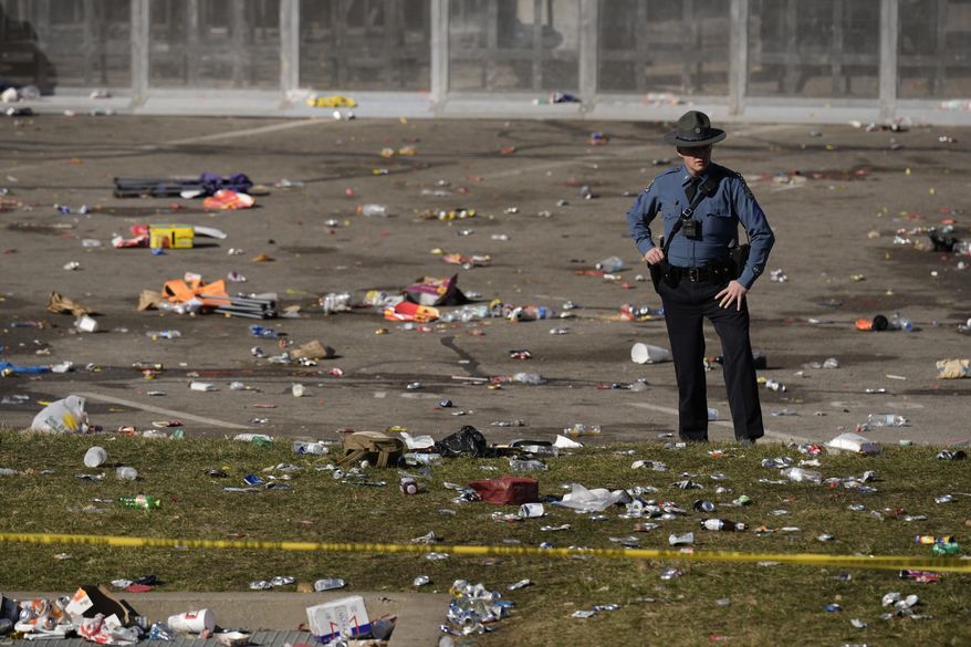 A law enforcement officer stands amid debris as he looks around the scene following a shooting at the Kansas City Chiefs NFL football Super Bowl celebration in Kansas City, Mo., Wednesday, Feb. 14, 2024. (AP Photo/Charlie Riedel, File)