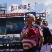 Washington Nationals principal owner Mark Lerner stands with Nationals manager Dave Martinez, second from left, coaches and players during a rendition of the national anthem before a baseball game against the Cincinnati Reds, Tuesday, July 4, 2023, in Washington. (AP Photo/Patrick Semansky) **FILE**