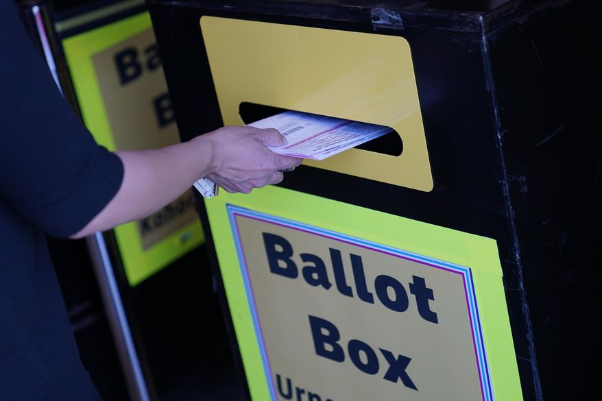 A person places mail-in ballots at a mail-in ballot drop box at the Clark County Election Department, Oct. 29, 2020, in Las Vegas. The Supreme Court has rejected a challenge to Texas' mail-in voter law by a group of voters who allege that it discriminates on the basis of age. (AP Photo/John Locher, File)