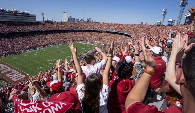 Oklahoma fans celebrate a touchdown during the first half of an NCAA college football game against Texas at the Cotton Bowl, Saturday, Oct. 7, 2023, in Dallas. The ESPN “College GameDay” analyst Kirk Herbstreit and the network&#x27;s broadcaster Chris Fowler announced Thursday, Feb. 22, 2024, on social media they will be voices in EA Sports&#x27; upcoming college football video game. (AP Photo/Jeffrey McWhorter, File)