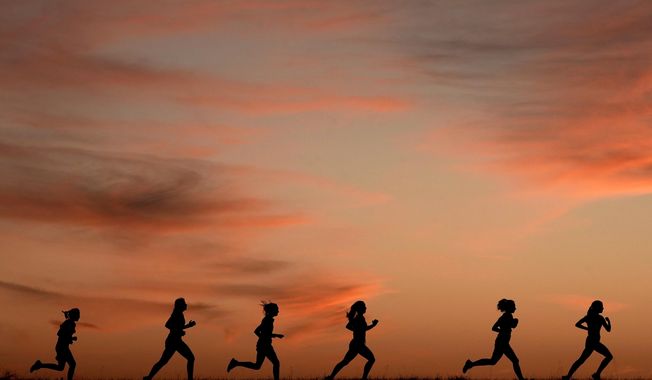 High school students run at sunset as they practice for the track and field season Monday, Feb. 28, 2022, in Shawnee, Kan. The killing of a 22-year-old nursing student has once again put the spotlight on dangers faced by female athletes who practice sports alone. (AP Photo/Charlie Riedel, File)