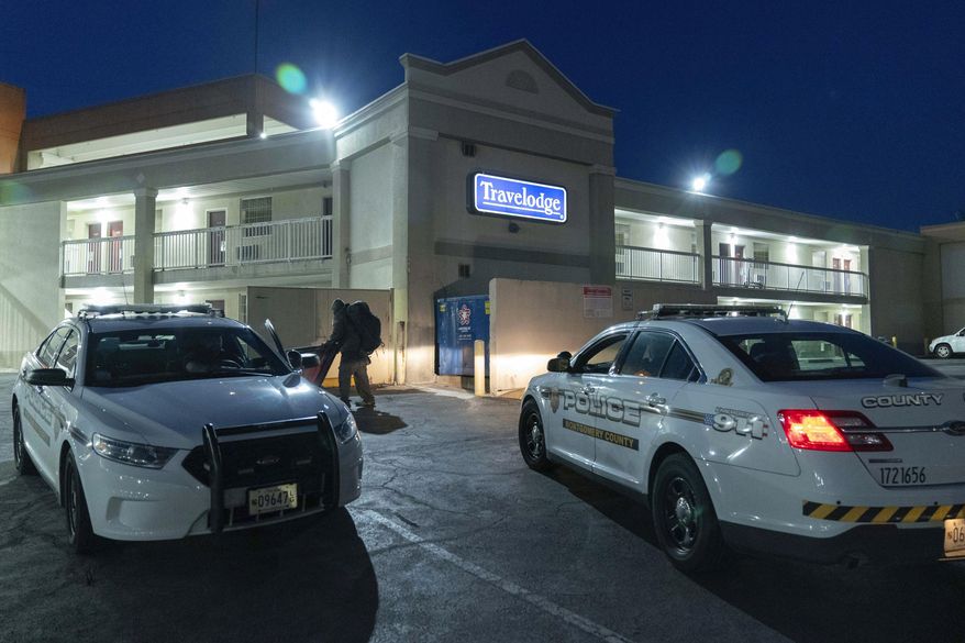 Montgomery County, Md., police cars sit in the parking lot at the Travelodge hotel in Silver Spring, Md., Monday, Feb. 26, 2024. Aaron Bushnell of San Antonio, an active-duty member of the U.S. Air Force has died after he set himself ablaze outside the Israeli Embassy in Washington. Investigators believe Bushnell had been staying at a Travelodge in Silver Spring, Maryland, which was searched Monday by federal agents, a law enforcement official said. (AP Photo/Jose Luis Magana)