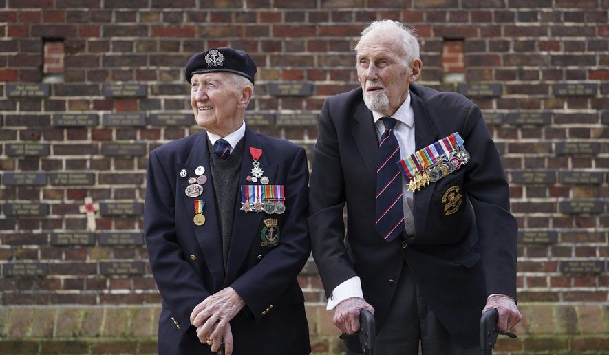 D-Day veterans Stan Ford, left, and John Roberts before receiving their memorial plaques in front of the Normandy Memorial Wall in Portsmouth, England, Tuesday Feb. 27, 2024. With medals pinned to their chests, the two D-Day veterans proudly represented their comrades as 13 new names were added to the memorial wall in southern England that honors those who took part in the Normandy landings. (Gareth Fuller/PA via AP)