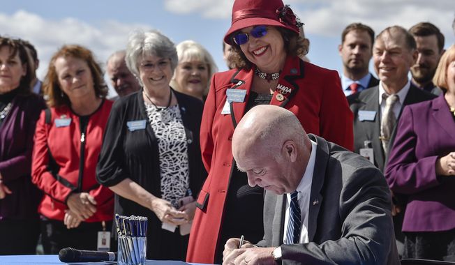 Republican Gov. Greg Gianforte signs a bill, April 26, 2021, that bans abortions after 20 weeks gestational age as bill sponsor Rep. Lola Sheldon-Galloway, R-Great Falls, looks on in Helena, Mont. A Montana judge ruled on Thursday, Feb. 29, 2024, that Sheldon-Galloway&#x27;s bill and two others restricting abortion that were passed by the Republican-controlled Legislature in 2021 are unconstitutional. (Thom Bridge/Independent Record via AP, File)