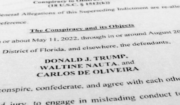The updated indictment against former President Donald Trump, Walt Nauta and Carlos De Oliveira is photographed July 27, 2023. The federal judge in Florida presiding over the classified documents prosecution of former President Donald Trump has canceled the May 20 trial date, postponing it indefinitely. (AP Photo/Jon Elswick, File)