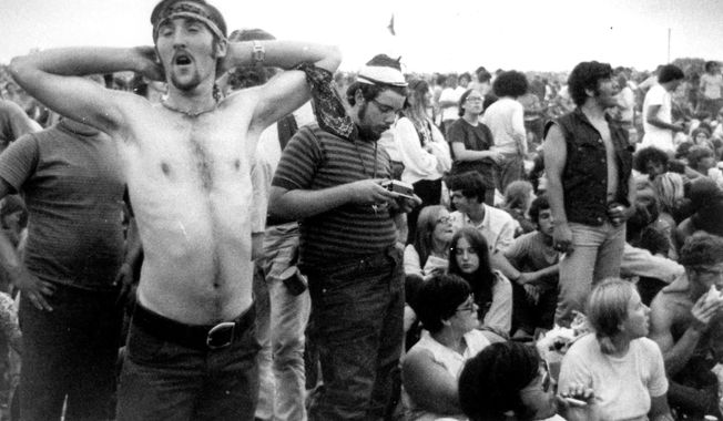 Music fans relax during a break in the entertainment at the Woodstock Music and Arts Fair, Aug. 16, 1969, in Bethel, N.Y. An estimated 450,000 people attended the Woodstock festival in August 1969, and most of that crowd was composed of teenagers or young adults now in the twilight of their lives. That ticking clock is why the Museum at Bethel Woods, based at the site of the festival, is immersed in a five-year project traveling around the United States recording the oral histories of people were there, preserving the Woodstock memories before they fade away. (AP Photo, File)