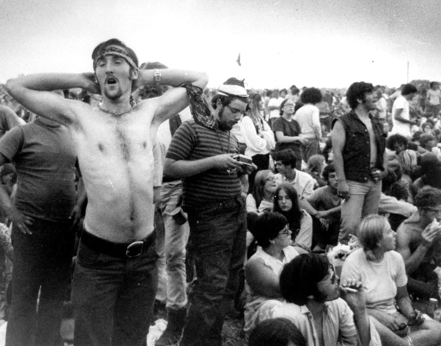 Music fans relax during a break in the entertainment at the Woodstock Music and Arts Fair, Aug. 16, 1969, in Bethel, N.Y. An estimated 450,000 people attended the Woodstock festival in August 1969, and most of that crowd was composed of teenagers or young adults now in the twilight of their lives. That ticking clock is why the Museum at Bethel Woods, based at the site of the festival, is immersed in a five-year project traveling around the United States recording the oral histories of people were there, preserving the Woodstock memories before they fade away. (AP Photo, File)