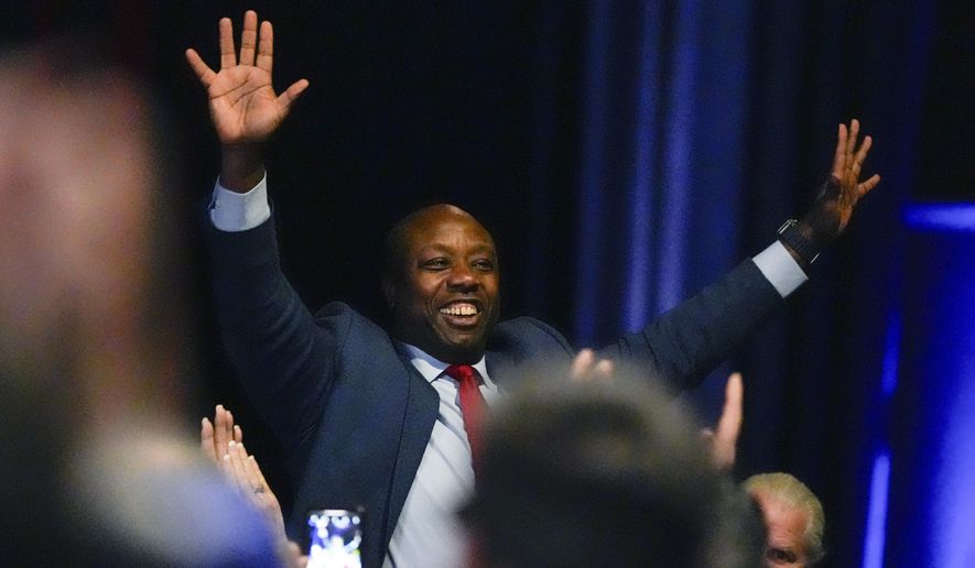 Sen. Tim Scott, R-S.C., waves as Republican presidential candidate former President Donald Trump speaks during a Fox News Channel town Hall Tuesday, Feb. 20, 2024, in Greenville, S.C. (AP Photo/Chris Carlson)