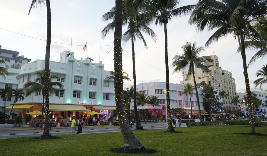 Pedestrians walk along Ocean Drive with its beautiful Art Deco buildings, Tuesday, Feb. 27, 2024, in Miami Beach, Fla. Miami Beach officials are implementing a series of measures to discourage non residents from going to South Beach for spring break. They include curfews, DUI checkpoints and closing parking garages. (AP Photo/Marta Lavandier)