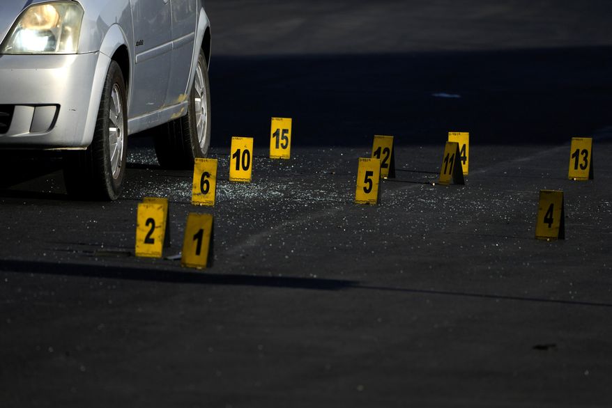 Evidence markers indicate the location of bullet casings at a crime scene where police say a fellow officer was fatally shot by cartel gunmen, in Celaya, Mexico, Feb. 28, 2024. At least 34 police officers have been killed in this city of 500,000 in the last three years. (AP Photo/Fernando Llano, File)