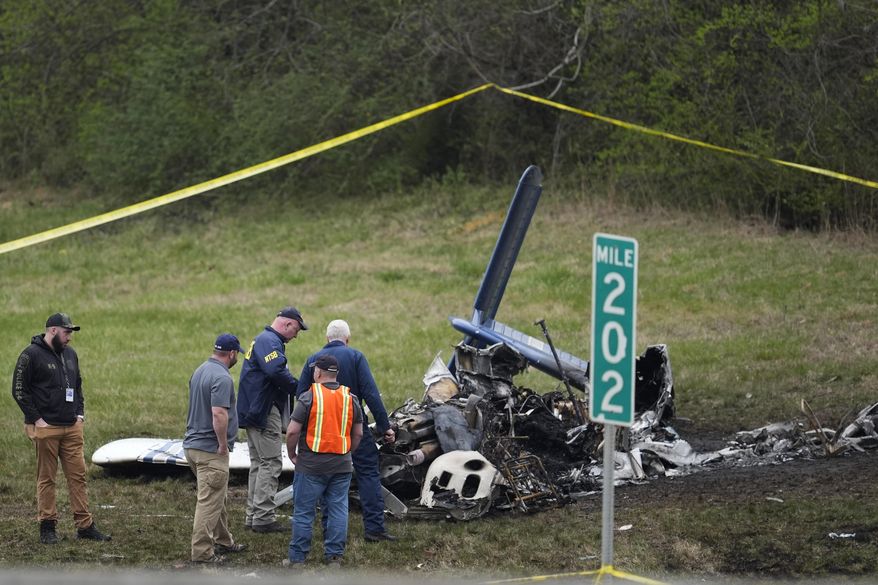 Investigators look over a small plane crash alongside eastbound Interstate 40 at mile marker 202 on Tuesday, March 5, 2024, in Nashville, Tenn. On Thursday, Police have identified those killed in the fiery small plane crash next to Interstate 40 on Monday as a family of five from Canada. (AP Photo/George Walker IV)