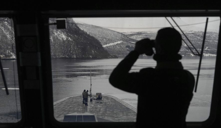 A French sailor uses binoculars to scan the area as others stand on the bow of the French navy frigate Normandie during a docking manoeuvre in a Norwegian fjord, north of the Arctic circle, Friday March 8, 2024. The French frigate is part of a NATO force conducting exercises in the seas, north of Norway, codenamed Steadfast Defender, which are the largest conducted by the 31 nation military alliance since the cold war. (AP Photo/Thibault Camus)
