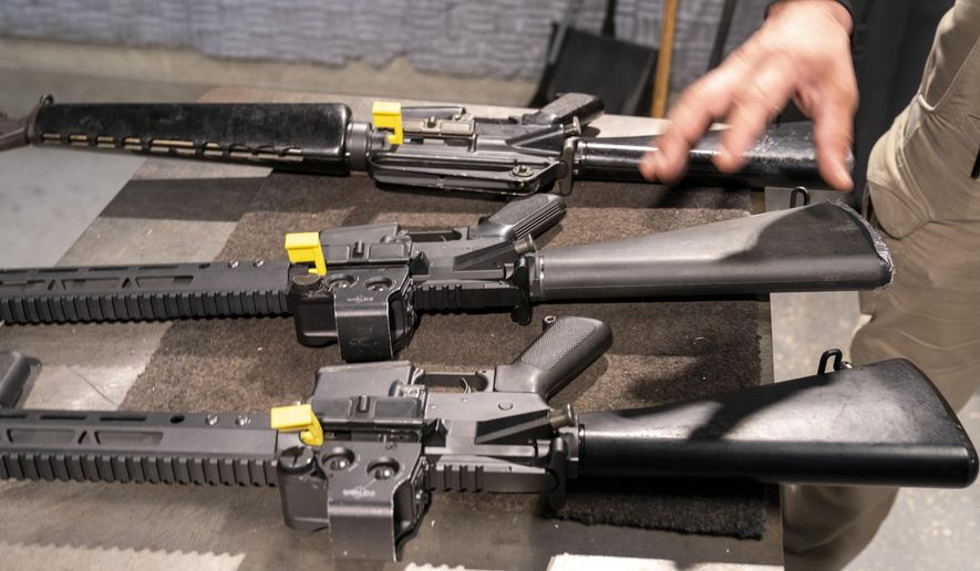 A row of AR-15 style rifles is displayed for a photograph, one with a conversion device installed making it fully automatic, and one a fully automatic M-16 machine gun, at the Bureau of Alcohol, Tobacco, Firearms, and Explosives (ATF), National Services Center, Thursday, March 2, 2023, in Martinsburg, W.Va. Machine guns have been illegal in the U.S. for decades, but in recent years the country has seen a new surge of weapons capable of automatic fire. Small pieces of plastic or metal used to convert legal guns into homemade machine guns are helping to fuel gun violence. (AP Photo/Alex Brandon)