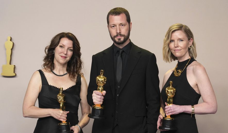 Raney Aronson-Rath, from left, Mstyslav Chernov, and Michelle Mizner pose in the press room with the award for best documentary feature film for "20 Days in Mariupol" at the Oscars on Sunday, March 10, 2024, at the Dolby Theatre in Los Angeles. (Photo by Jordan Strauss/Invision/AP)
