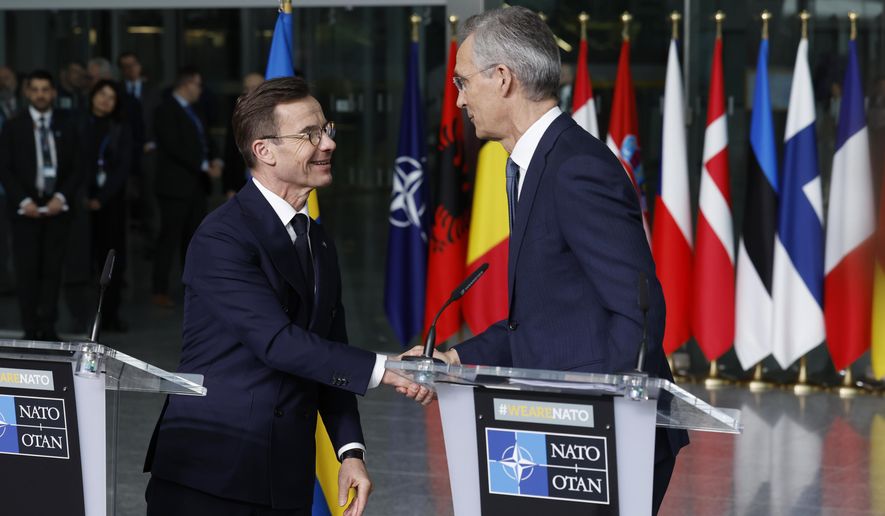 NATO Secretary General Jens Stoltenberg, right, and Sweden's Prime Minister Ulf Kristersson shake hands during a media conference prior to a flag raising ceremony to mark the accession of Sweden to NATO at NATO headquarters in Brussels, Monday, March 11, 2024. (AP Photo/Geert Vanden Wijngaert)