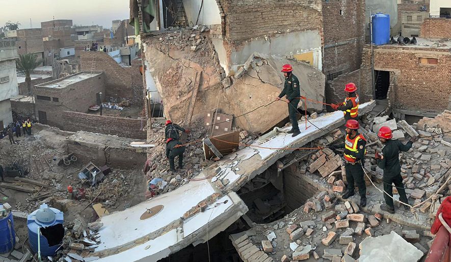 In this photo released by Rescue 1122 Emergency Department, rescue workers search survivors through the rubble of a collapsed residential building, in Multan, Pakistan, Tuesday, March 12, 2024. A three-story residential building collapsed in central Pakistan early Tuesday, leaving some people dead, authorities said. (Rescue 1122 Emergency Department via AP)