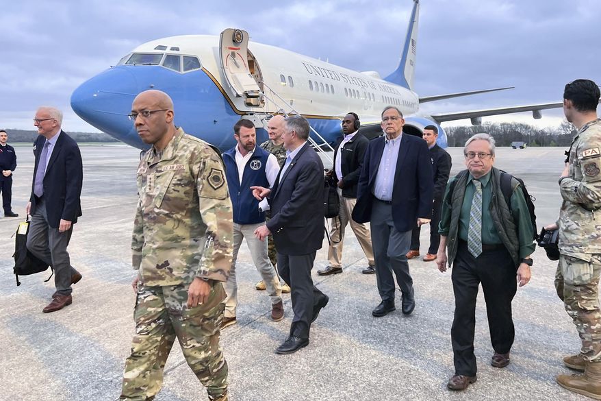 Joint Chiefs Chairman Gen. Charles Q. Brown Jr. arrives at Little Rock Air Force Base, Thursday, March 14, 2024, in Little Rock, Arkansas, with Sen. Markwayne Mullin, R-Ok., left, Rep. Bruce Westerman, R-Ark., center, and Sen. John Boozman, R-Ark., right. The chairman is traveling with the lawmakers to visit two weapons facilities in Arkansas and Oklahoma that are producing munitions critical to Ukraine. (AP Photo/Tara Copp)
