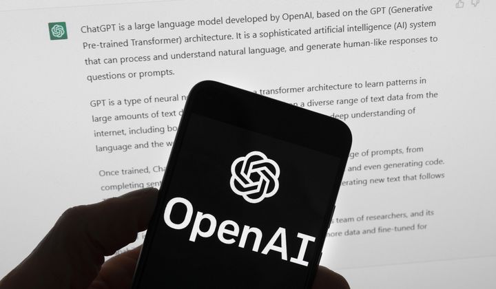 The OpenAI logo is seen on a mobile phone in front of a computer screen which displays output from ChatGPT, March 21, 2023, in Boston. A wave of AI deepfakes tied to elections in Europe and Asia has coursed through social media for months, serving as a warning for more than 50 countries heading to the polls this year. (AP Photo/Michael Dwyer, File)