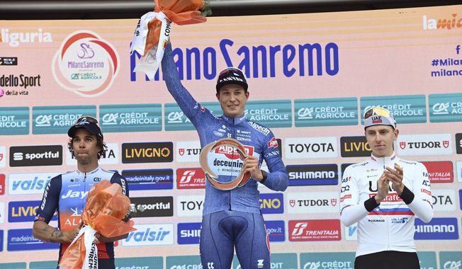 Belgium's Jasper Philipsen, center, winner of the Milan to Sanremo cycling race, poses with second placed Australia's Michael Matthews, left, and third placed Slovenia's Tadej Pogacar in San Remo, Italy, Saturday, March 16, 2024. (Gian Mattia D'Alberto/LaPresse via AP)