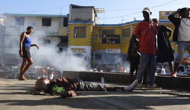 EDS NOTE: GRAPHIC CONTENT - A body lies on the ground after an overnight shooting in the Petion Ville neighborhood of Port-au-Prince, Haiti, Monday, March 18, 2024. (AP Photo/Odelyn Joseph)