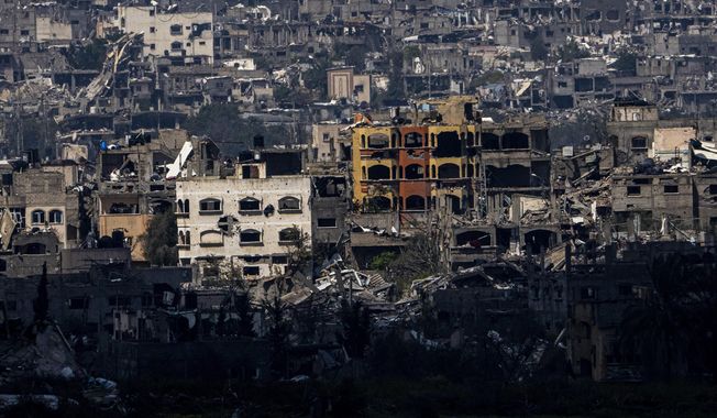 Destroyed buildings stand inside the Gaza Strip, as seen from southern Israel, Tuesday, March 19, 2024. (AP Photo/Ariel Schalit)