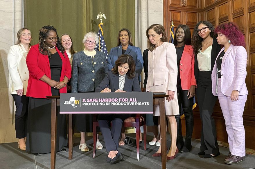 New York Gov. Kathy Hochul, center, signs bills expanding reproductive healthcare that will allow people in New York to receive contraceptives without a doctor's prescription, May 2, 2023, in Albany, N.Y. New Yorkers will be able to get contraceptives without a prescription under a standing order signed by state health officials on Tuesday, March 19, 2024. The move is part of Hochul's mission to bolster reproductive rights at a time when its restricted in other parts of the country. (AP Photo/Maysoon Khan, File)