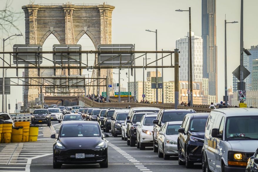 Traffic enters lower Manhattan after crossing the Brooklyn Bridge, Feb. 8, 2024, in New York. The Biden administration this week is expected to announce new automobile emissions standards that relax proposed limits in the next few years but reach the same strict standards outlined by the Environmental Protection Agency last year. (AP Photo/Bebeto Matthews) **FILE**