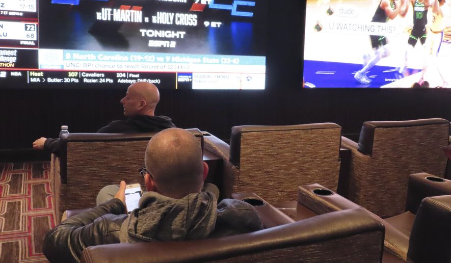 NCAA basketball tournament brackets are displayed on video screens at the Golden Nugget casino in Atlantic City N.J. on Wednesday, March 21, 2024. The American Gaming Association estimates Americans will wager $2.72 billion with legal outlets this year. (AP Photo/Wayne Parry)