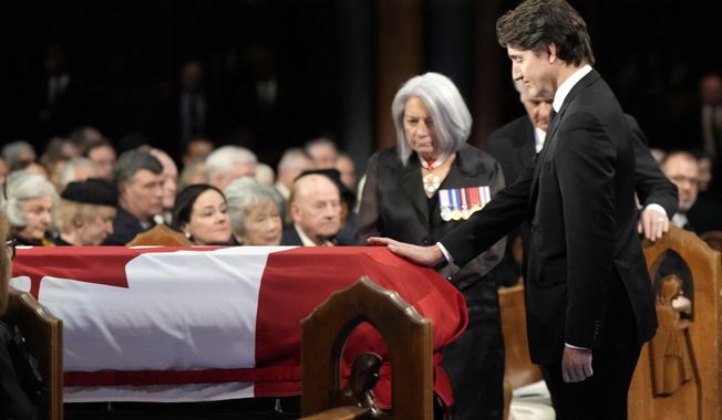 Prime Minister Justin Trudeau places his hand on the casket during the funeral of former prime minister Brian Mulroney, in Montreal, Saturday, March 23, 2024. (Ryan Remiorz /The Canadian Press via AP)