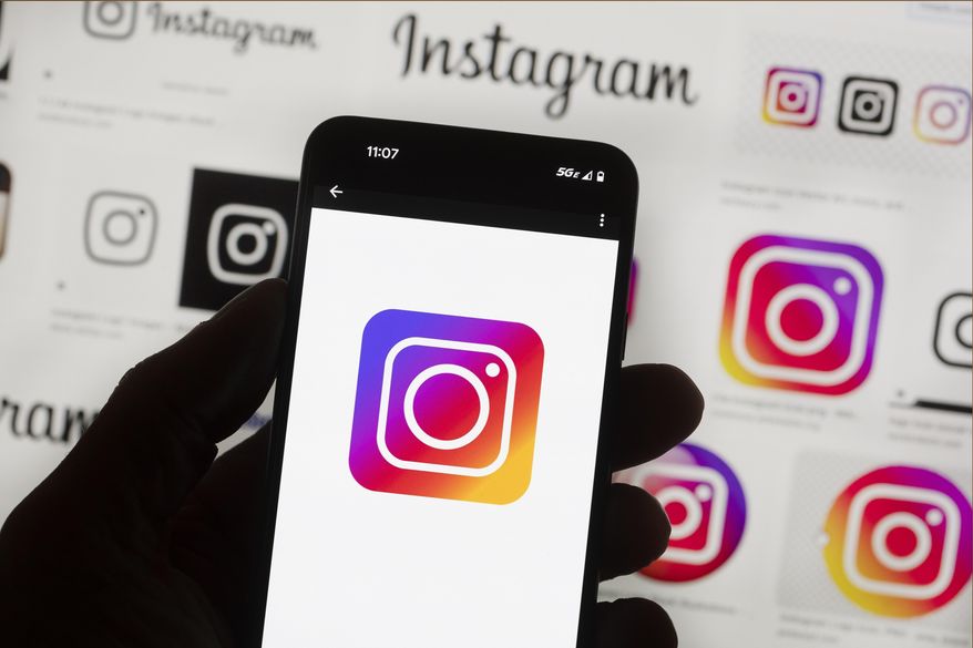 The Instagram logo is seen on a cell phone in Boston, USA, Oct. 14, 2022. Instagram has started an automatic clamp down on the amount of political content appearing in its users' feeds, Saturday, March 23, 2024, but there is a relatively quick and easy way to turn off the controls if you don't want to keep the limitations place.(AP Photo/Michael Dwyer, File)