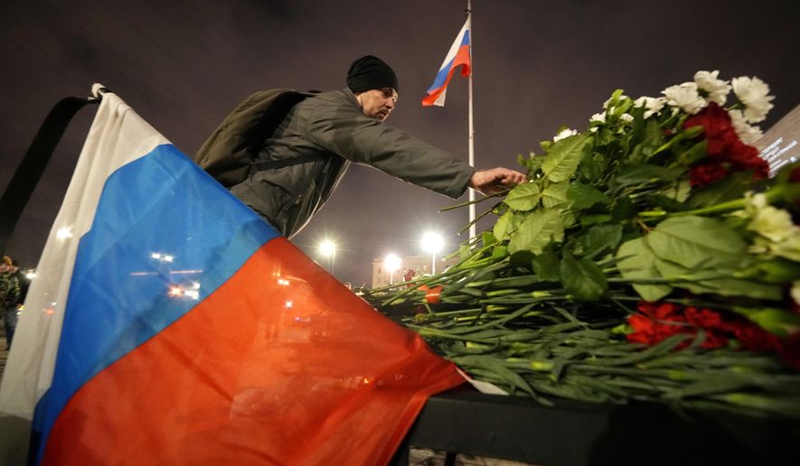 A man places flowers at a spontaneous memorial in memory of the victims of Moscow attack in St. Petersburg, Russia, Saturday, March 23, 2024. Russia&#x27;s top state investigative agency says the death toll in the Moscow concert hall attack has risen to over 133. The attack Friday on Crocus City Hall, a sprawling mall and concert venue on Moscow&#x27;s western edge, also left many wounded and left the building a smoldering ruin. (AP Photo/Dmitri Lovetsky)