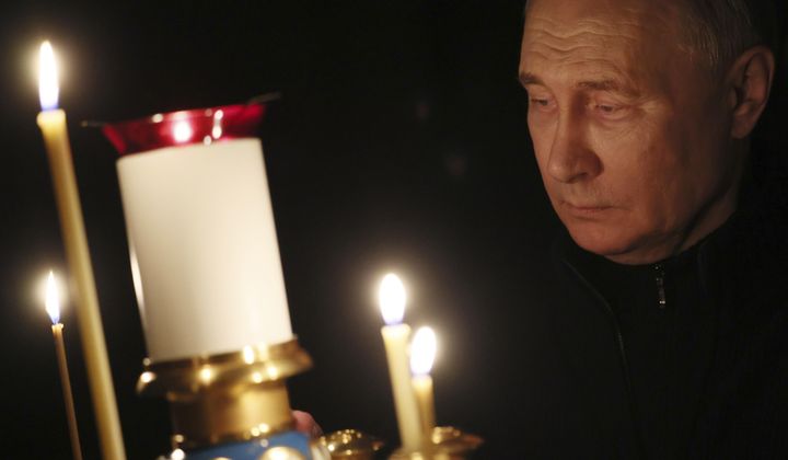 Russian President Vladimir Putin lights a candle to commemorate the victims of an attack on the Crocus City Hall concert venue, on the day of national mourning, in Russia, Sunday, March 24, 2024. (Mikhail Metzel, Sputnik, Kremlin Pool Photo via AP)