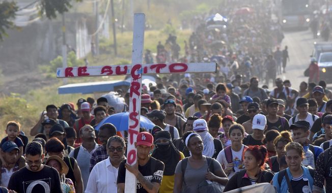 Migrants walking on the highway carry a cross that reads in Spanish &quot;Christ Resurrected&quot; during Holy Week as they move through Tapachula in Mexico&#x27;s Chiapas state, Monday, March 25, 2024. Migrants stranded on the border with Guatemala departed on Monday for Mexico City in what they are calling &quot;The Migrant Way of the Cross&quot; to call for better migratory policies. (AP Photo/Edgar H. Clemente)