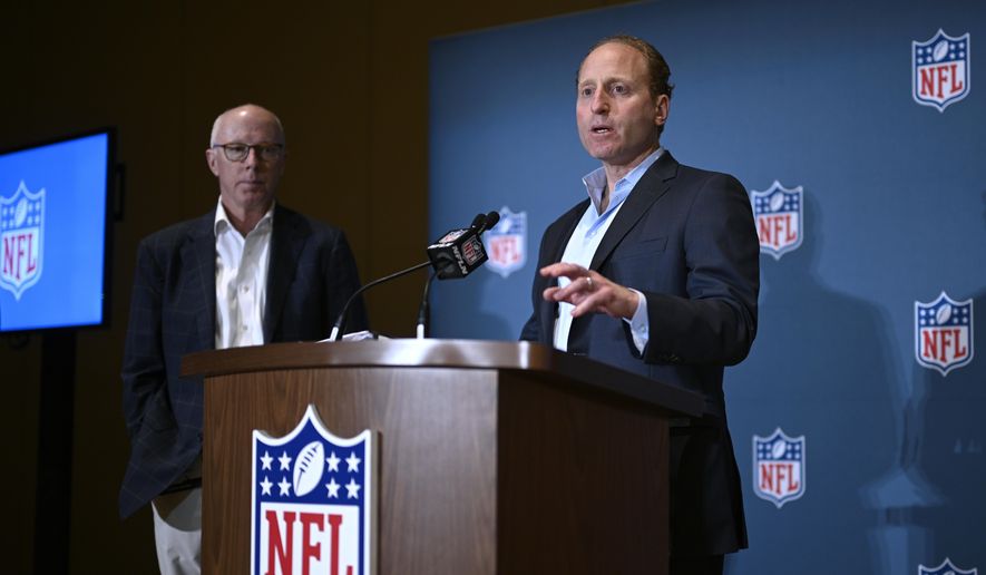 Rich McKay, left, Atlanta Falcons CEO and Competition Committee Chairman, looks on as Jeff Miller, NFL Executive Vice President of Communications, addresses reporters about rules changes at the NFL owners meetings, Monday, March 25, 2024, in Orlando, Fla. (AP Photo/Phelan M. Ebenhack)