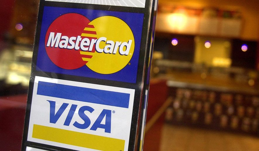 This April 22, 2005, file photo shows logos for MasterCard and Visa credit cards at the entrance of a New York coffee shop. (AP Photo/Mark Lennihan, File)