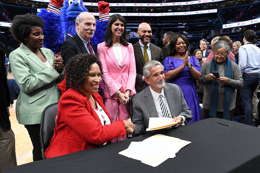 Monumental Sports & Entertainment chief executive Ted Leonsis and D.C. Mayor Muriel E. Bowser shaking hands after signing an agreement that would keep the Wizards and Capitals at Capital One Arena in Washington D.C. until 2050, March 27, 2024. (Photo by Jack Sabatini)