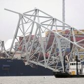 A cargo ship is stuck under the part of the structure of the Francis Scott Key Bridge after the ship hit the bridge Wednesday, March 27, 2024, in Baltimore, Md. (AP Photo/Steve Helber)