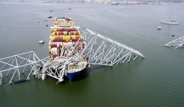 In this aerial image released by the Maryland National Guard, the cargo ship Dali is stuck under part of the structure of the Francis Scott Key Bridge after the ship hit the bridge, Tuesday, March 26, 2024, in Baltimore. (Maryland National Guard via AP)