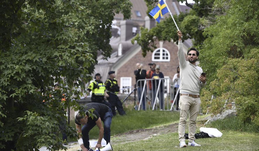 Protestor Salwan Momika waves the Swedish flag outside the Iraqi embassy in Stockholm, on July 20, 2023, where he plans to burn a copy of the Quran and the Iraqi flag. Momika, an Iraqi man who carried out several Quran burnings in Sweden told a newspaper on Wednesday March 27, 2024 that he would seek asylum in neighboring Norway in the wake of a deportation order by authorities in Stockholm. (Oscar Olsson/TT via AP, File)