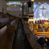 A second floor set of pews sits empty as a projection of a sermon is displayed on a wall during Palm Sunday services at the Metropolitan AME Church in Washington, Sunday, March 24, 2024. Rev. William Lamar IV at Washington, D.C.’s historic Metropolitan AME has adjusted to offering both virtual and in-person services since the COVID-19 pandemic. After a noticeable attendance drop, more Metropolitan congregants are choosing in-person worship over virtual, even as they mourn members who died from COVID-19. (AP Photo/Amanda Andrade-Rhoades)