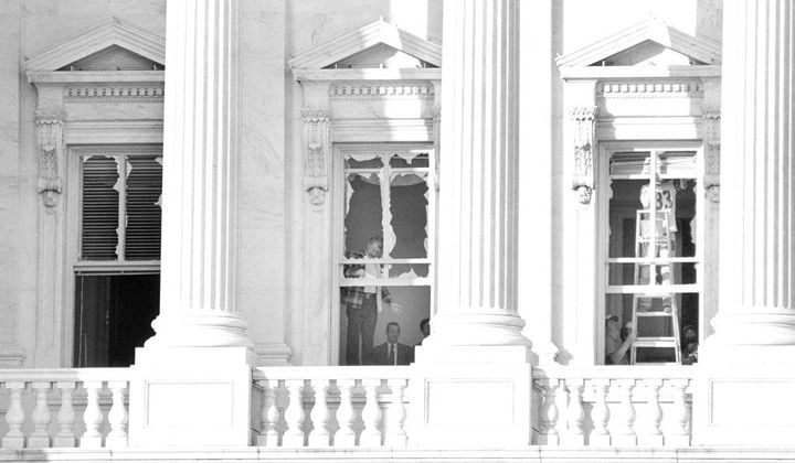 Unidentified people examine two of the three windows, Nov. 8, 1983, that were blown out the night before, as a result of the bomb blast that caused damage inside the building of the U.S. Capitol. (AP Photo/Ira Schwarz) ** FILE **