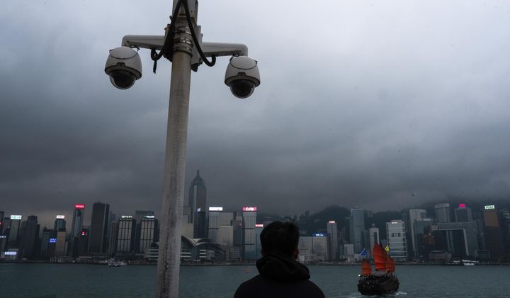 Surveillance cameras are seen as a visitor looks at Victoria Harbour in Hong Kong, Monday, March 11, 2024. The president of U.S.-funded Radio Free Asia said its Hong Kong bureau has been closed because of safety concerns under a new national security law, deepening concerns about the city’s media freedoms. Bay Fang, the president of RFA, said in a statement Friday March 29, 2024 that it will no longer have full-time staff in Hong Kong, although it would retain its official media registration. (AP Photo/Louise Delmotte, File)