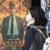 People walk by a poster to promote the movie &quot;Oppenheimer&quot; Friday, March 29, 2024, in Tokyo. “Oppenheimer” finally premiered Friday in the nation where two cities were obliterated 79 years ago by the nuclear weapons invented by the American scientist who was the subject of the Oscar-winning film. Japanese filmgoers&#x27; reactions understandably were mixed and highly emotional. (AP Photo/Eugene Hoshiko)