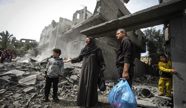 Palestinians collect their belongings from the rubble of a residential building for the Moussa family after an Israeli airstrike in the Maghazi refugee camp, central Gaza Strip, Friday, March 29, 2024. (AP Photo/Ismael Abu Dayyah) **FILE**